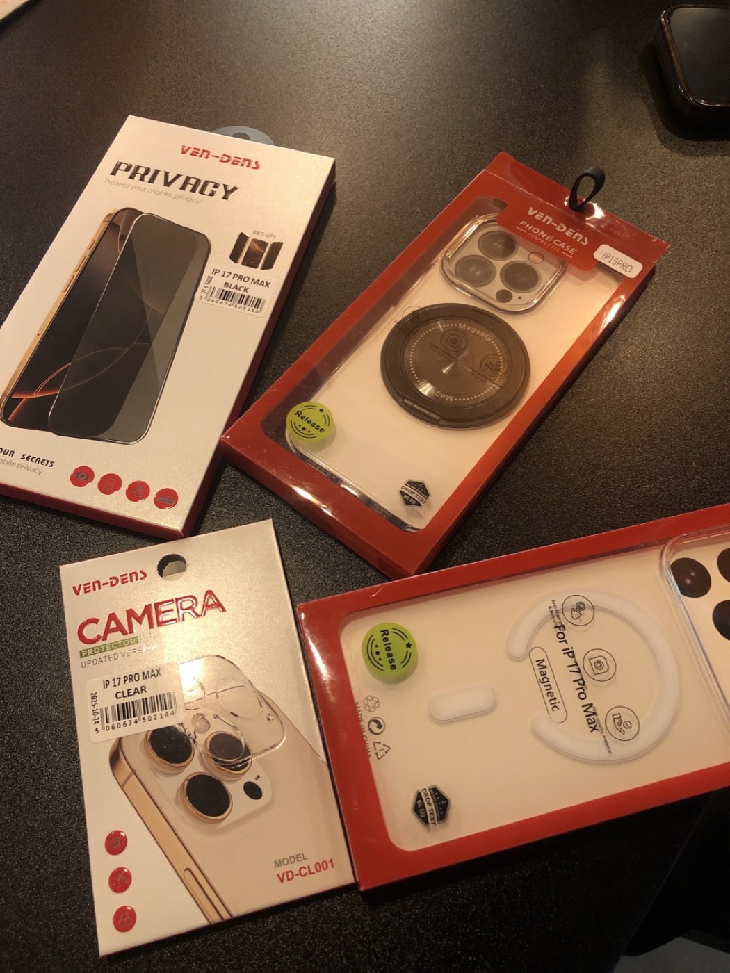 Boxed phone accessories on the Techmart counter: privacy screen protectors, camera lens protectors and clear MagSafe cases.